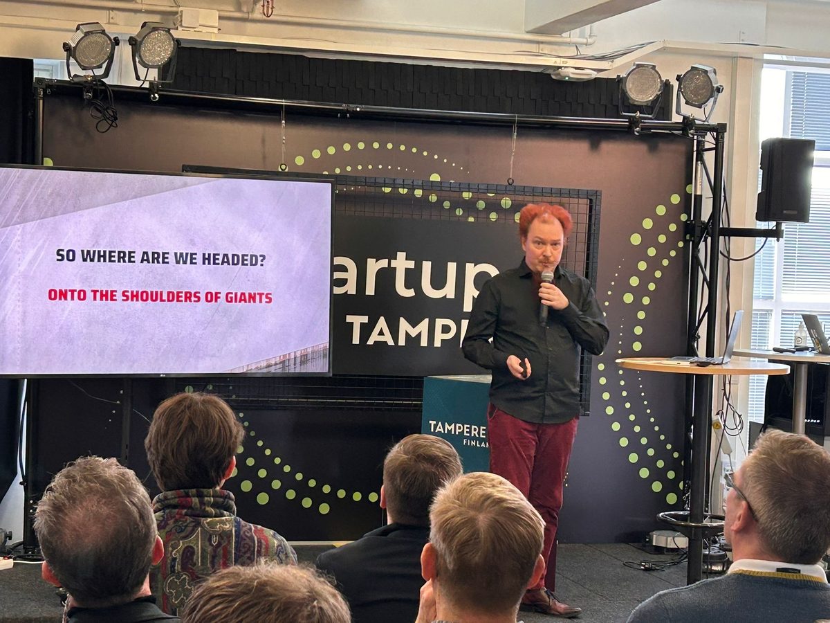 Jussi Autio speaking on stage in Tampere